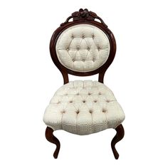 an antique chair with white upholstered fabric and wood frame, on a white background