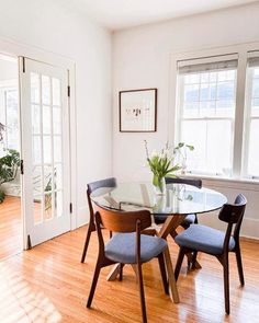 a glass table with four chairs in a room