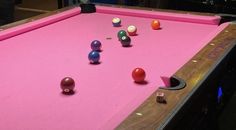 a pink pool table with several different colored balls