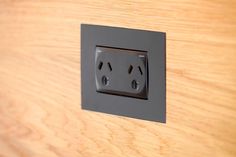 an electrical outlet on a wooden surface with two outlets in the middle and one socket at the end