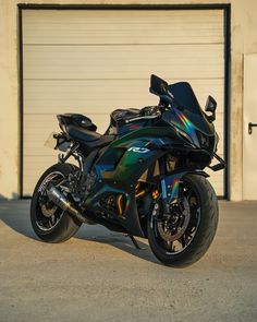 a black motorcycle parked in front of a garage