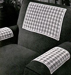 a black and white photo of a recliner chair with a plaid cover on it