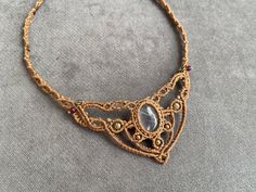 a gold necklace with an intricate design on it