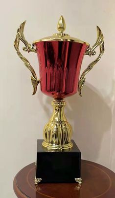 a red glass trophy sitting on top of a wooden table