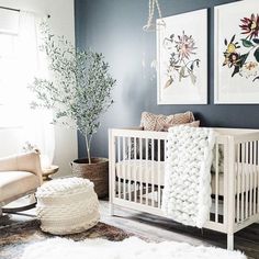 a baby's room with two pictures on the wall and a white crib
