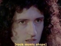 a man with long curly hair is looking at the camera and has an ad for rock music stops