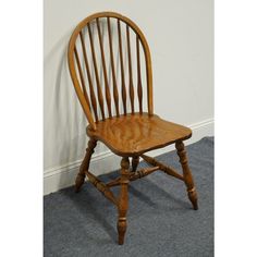 a wooden chair sitting on top of a carpeted floor