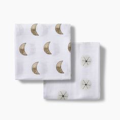 two white sheets with gold crescents and stars on them, one is folded to the side