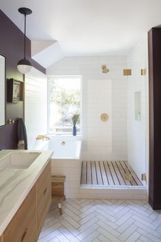 a bathroom with a tub, sink and shower in it's own area that is well lit by the window