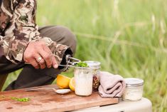 a man in camouflage is preparing food on a cutting board with utensils and spoons