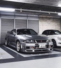 two cars parked next to each other in a garage