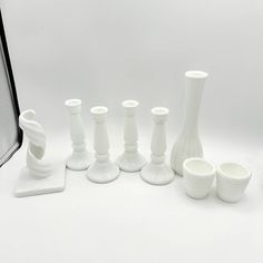 a group of white vases sitting next to each other