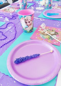 the table is set with purple paper plates and place settings for frozen princess party food