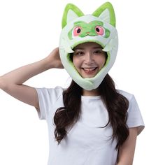 a woman wearing a green cat mask on her head