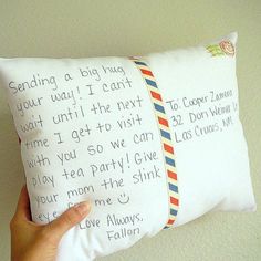 someone is holding up a pillow with writing on it