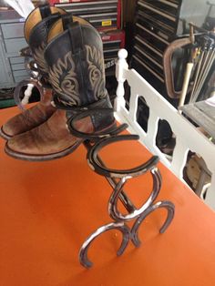 two pairs of cowboy boots sitting on top of a pair of metal clamps