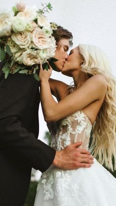 the bride and groom are kissing each other