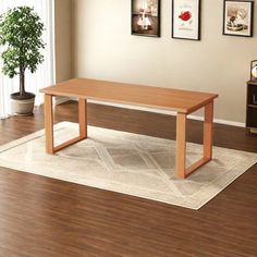 a wooden table sitting on top of a hard wood floor next to a potted plant