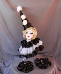 a black and white doll with a hat on it's head sitting on top of a table