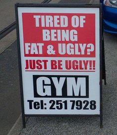 a sign that is on the side of the road advertising gyms and diet coke