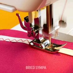 the sewing machine is working on the pink material that has been stitched into it