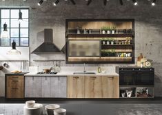 an industrial kitchen with wooden cabinets and white counter tops, stainless steel appliances and hanging lights