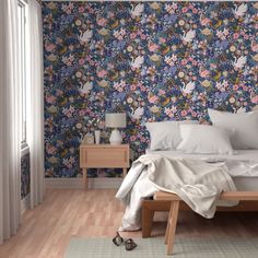 a bed sitting in a bedroom next to a wallpaper covered in lots of flowers