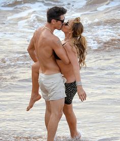 a man and woman kissing on the beach