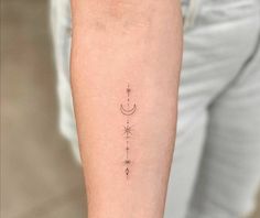 a woman's arm with an arrow and stars tattoo on the left inner arm