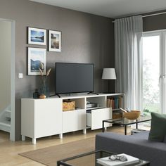 a living room filled with furniture and a flat screen tv on top of a white entertainment center