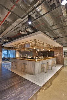 an open kitchen and bar area in a large room with lots of lights hanging from the ceiling