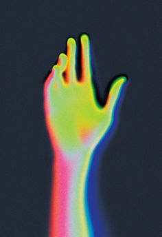 a person's hand with multicolored light coming out of the palm on a black background