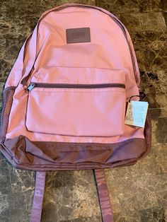 a pink backpack sitting on top of a marble floor