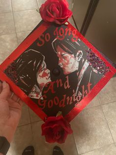 someone is holding up a graduation cap with an image of two people on it