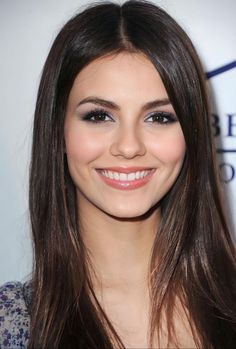 a woman with long brown hair smiling at the camera