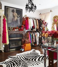 a zebra rug is in front of a closet full of clothes and accessories, with a chandelier hanging from the ceiling