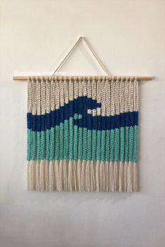 a macrame hanging on a wall with a blue and green design in the middle