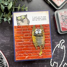 a card with an image of a cat on the brick wall and some other items around it