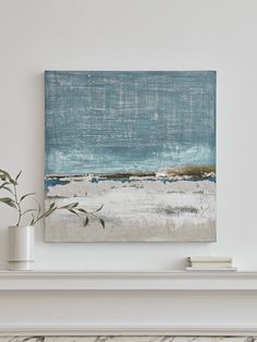 a painting is hanging on the wall above a fire place with a potted plant