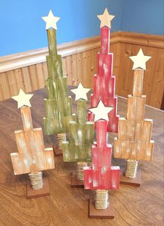 three wooden christmas trees with stars on them