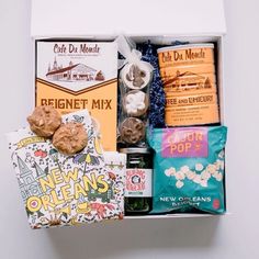 a box filled with treats and snacks on top of a white table next to a wall