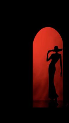 the silhouette of a woman wearing a hat in front of a red background with an arch