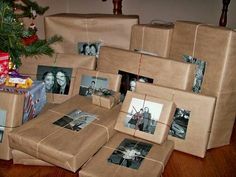 a pile of wrapped presents sitting on top of a wooden floor next to a christmas tree