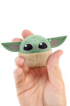 a hand holding a small toy in it's left hand with the baby yoda face on it