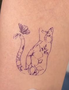 a cat with a butterfly on it's back leg, sitting next to a flower