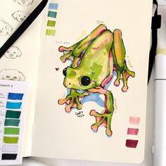 a drawing of a frog on paper next to markers