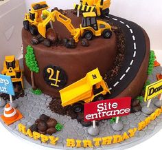 a birthday cake decorated with construction vehicles and road signs