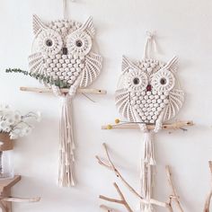 two white owls are hanging on the wall