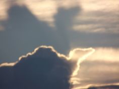 an airplane is flying in the sky with clouds behind it and sun shining through the clouds