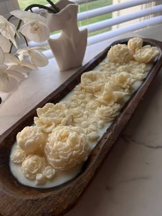 a wooden tray filled with white flowers on top of a table